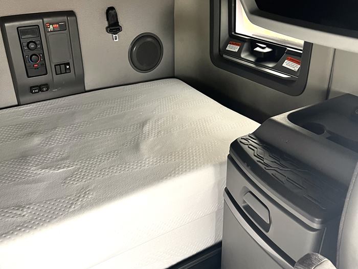 Truck sleeper cab with a mattress, climate control panel and a fridge